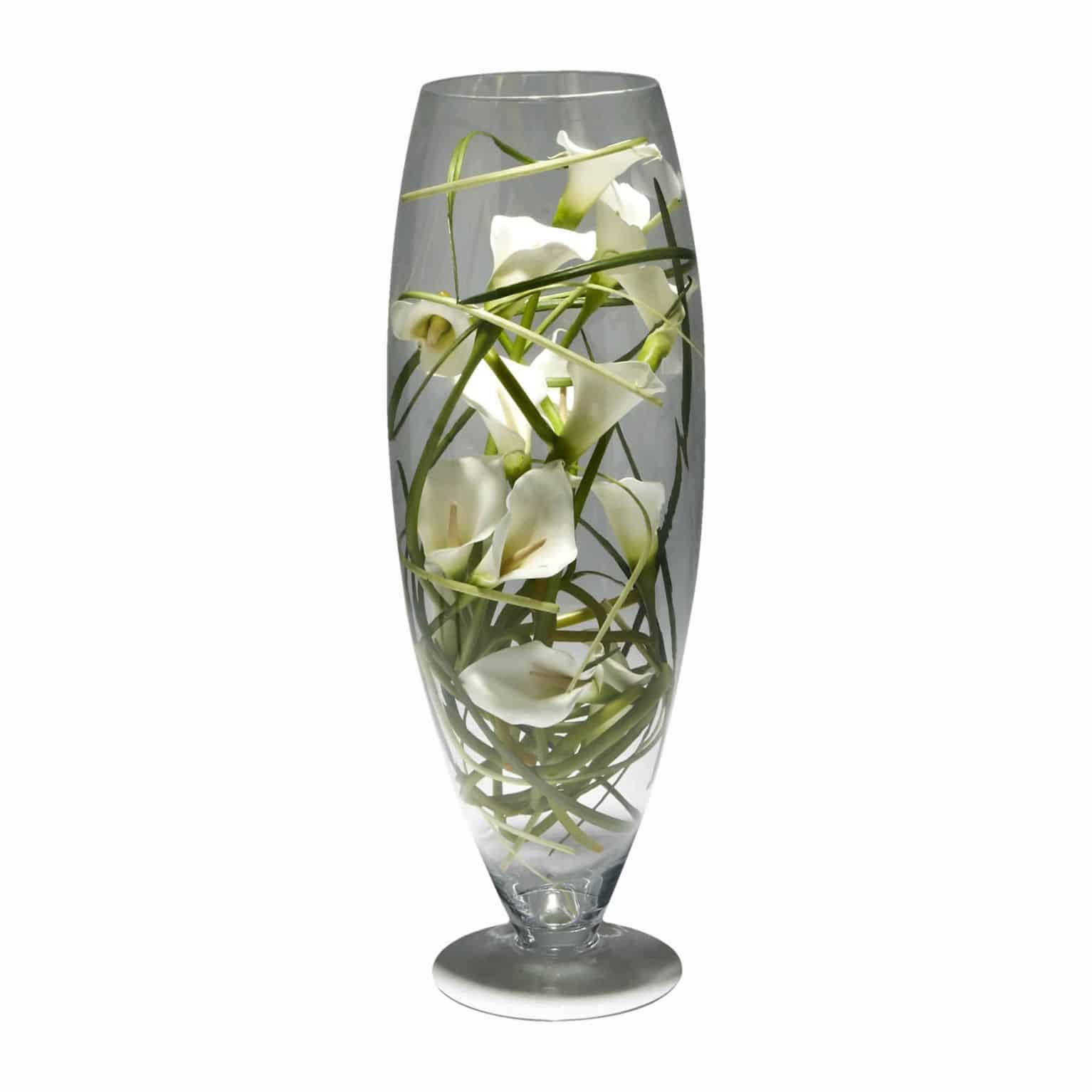 There is no reason to complicate a classic. Buy this luxuriously fine silk flowering calla lilies with meticulous detail arranged in a modern glass vase.