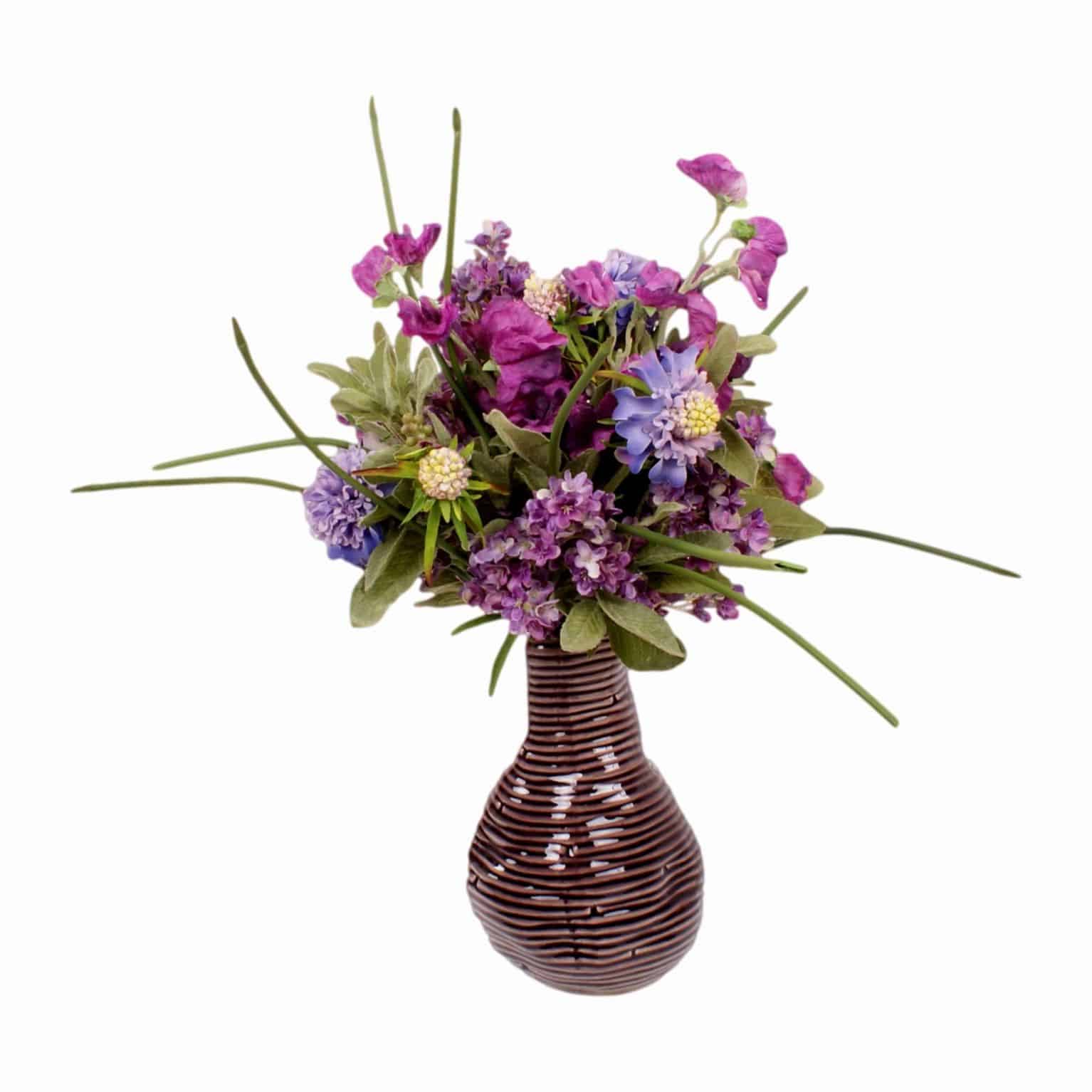 This arrangement will brush away those summer blues. Shop for our silk flowering sweet pea and lilac stems with artificial green leaves.