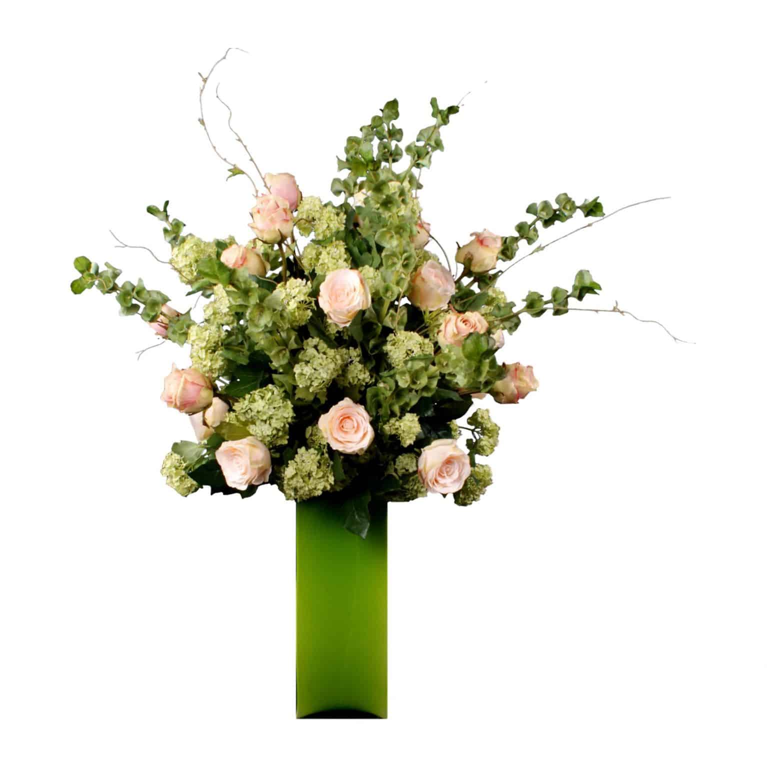 Shop for our pink Austrian and Ecuador silk rose arrangement with Guelder rose and Bells of Ireland. Designed in a contemporary square green glass vase.
